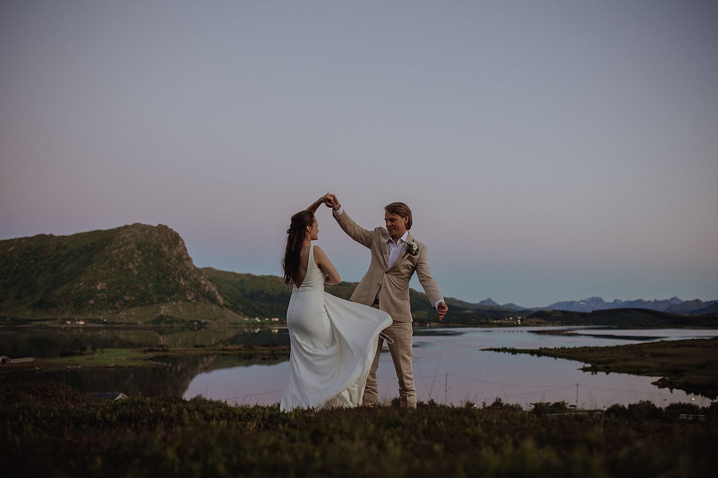 Brudepar som danser i solnedgangen i Lofoten